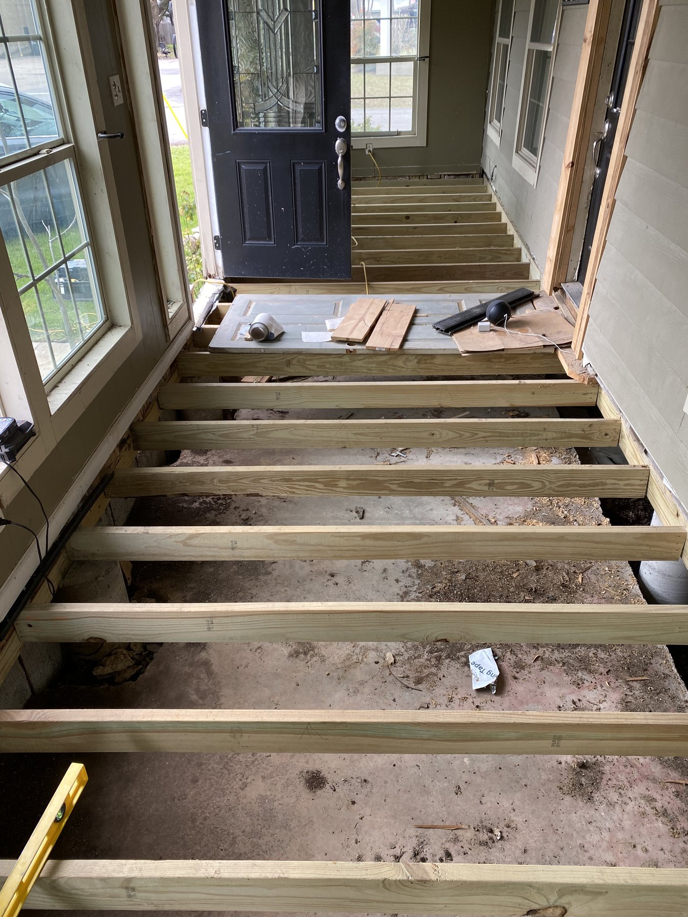 New floor framing built over previously open ground in the enclosed porch