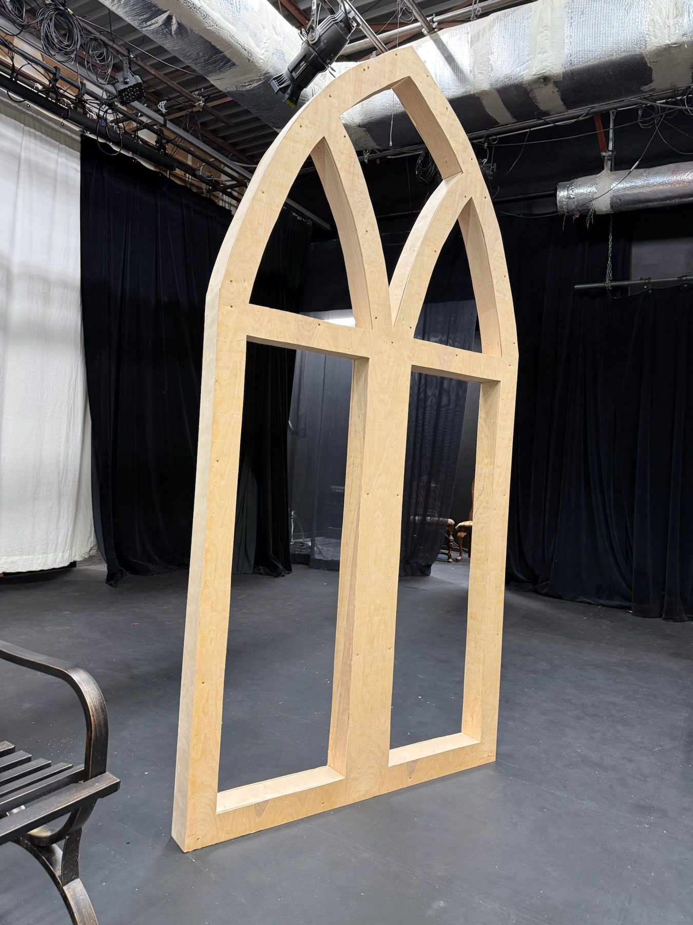Arched window-wall unit resting on stage before installation for Summer and Smoke