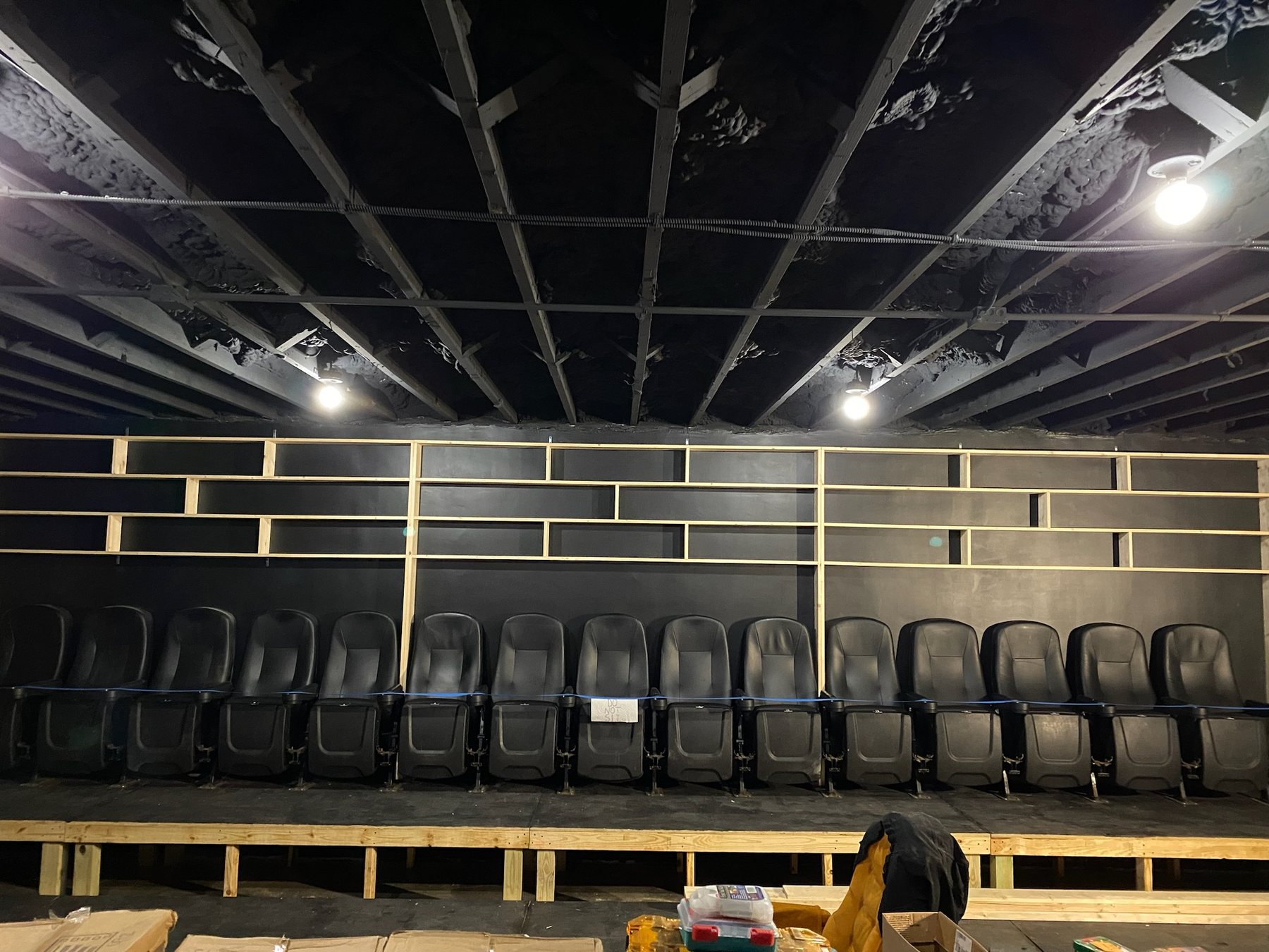 Custom shelving under construction around the cinema seating