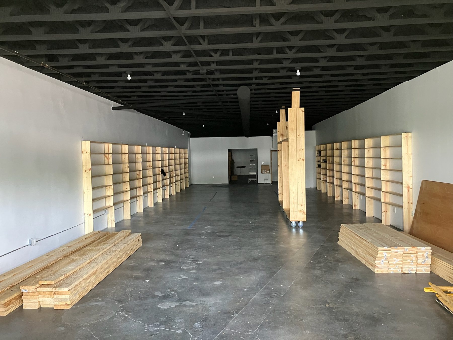 Custom shelving under construction inside We Luv Video