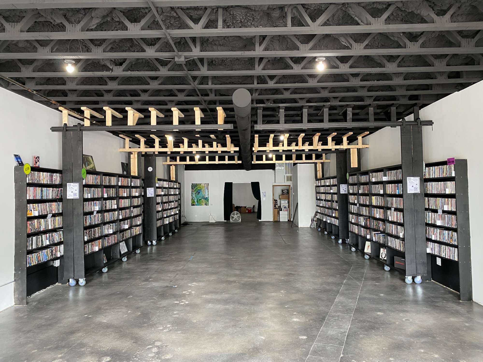 Full rolling media shelves beneath their overhead guide rails